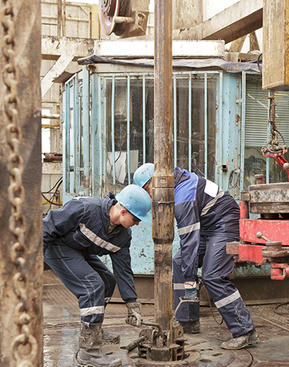 two men working on a pipe in a building